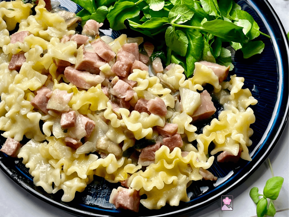 Ham Tetrazzini on a plate with a watercress salad also on the plate.