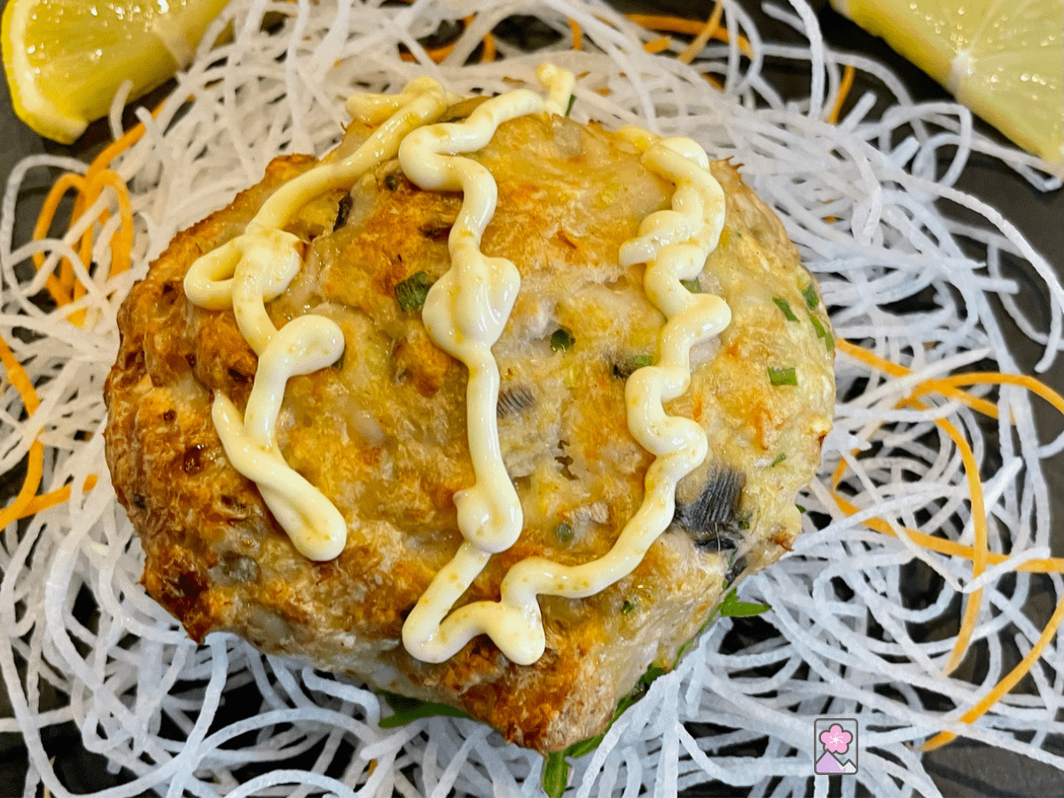 Shellfish Cake with Karasumi Mayonnaise on a bed of shredded daikon on a slate plate.