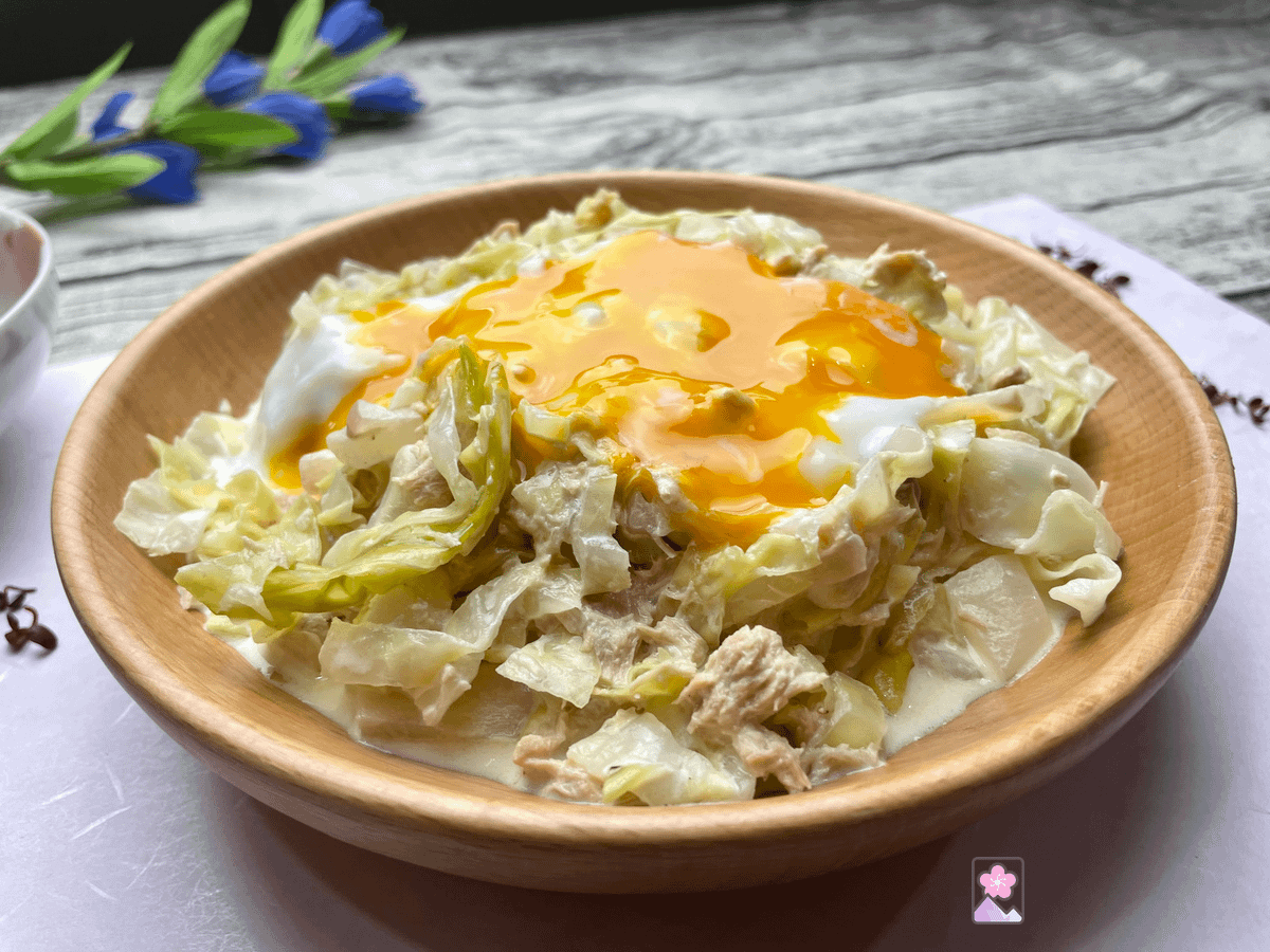 Tuna and Cabbage Salad in a wood bowl topped with a runny soft boiled egg