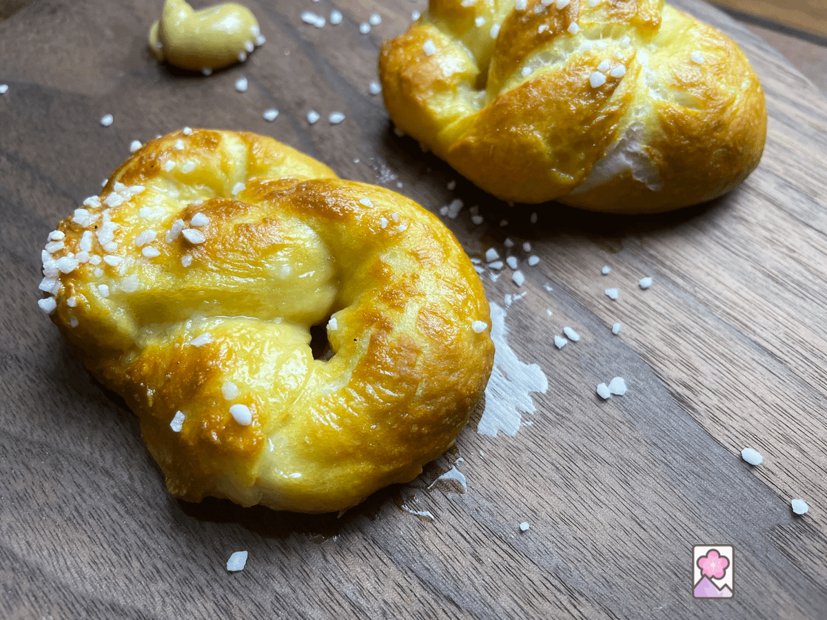 Soft pretzels on a wooden serving board with mustard.