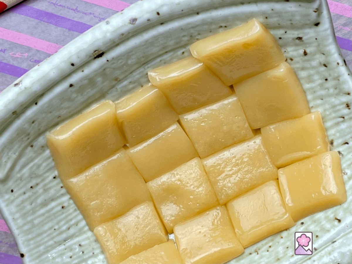 16 gooey soft caramel squares on a ceramic dish.