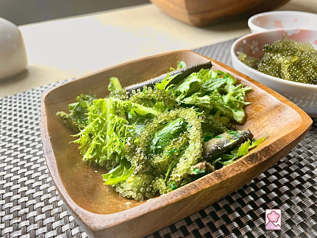 Sea Grapes and Smoked Sardine Salad with Wasabi Dressing is bursting with flavor and served in an acacia salad bowl on a tablecloth