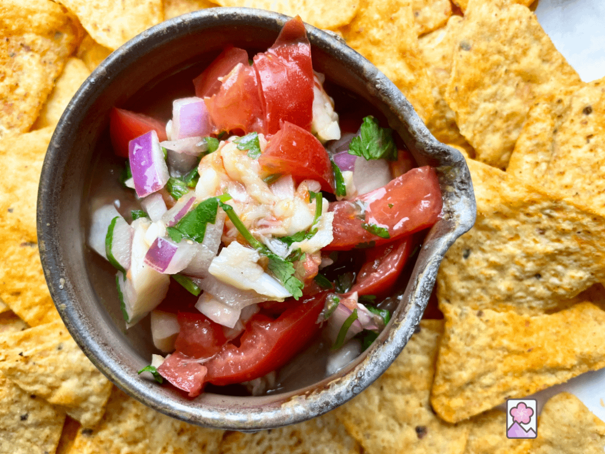 A close up photo from above of Japanese Shrimp and Scallpp Ceviche in a round ceramic bowl surrounded by tortilla chips