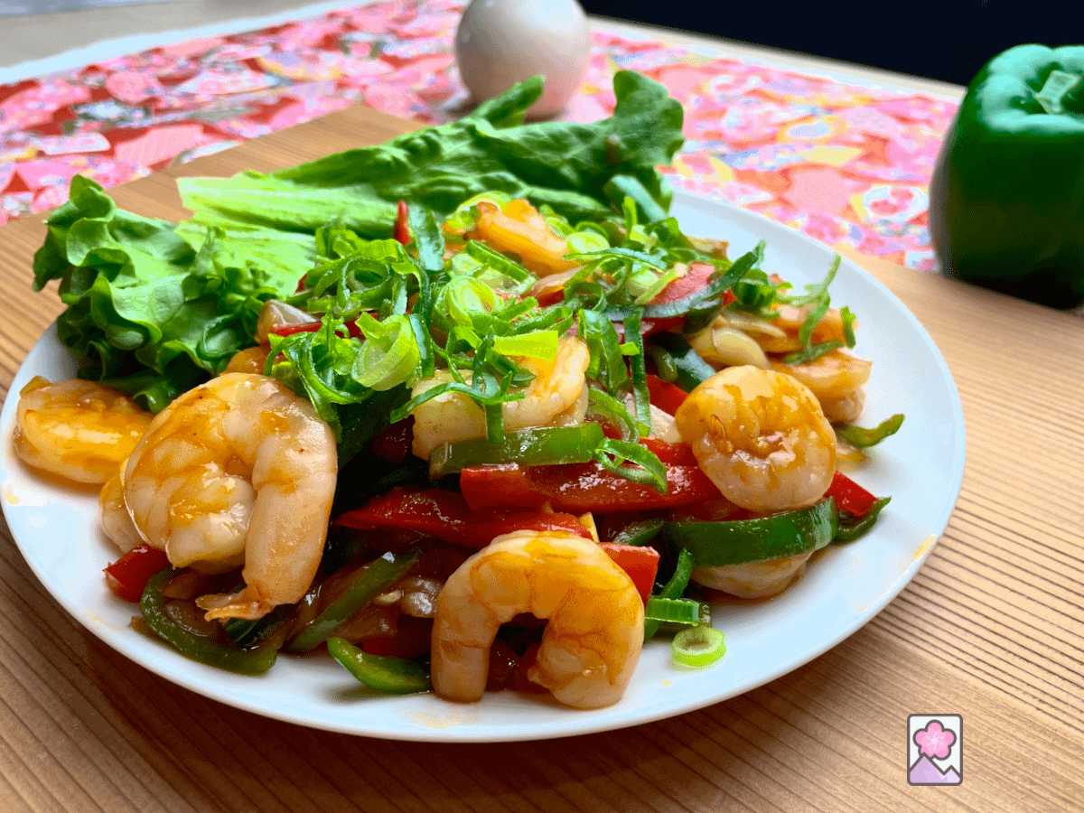 Ebi Chili, Shrimp with Chili Sauce, is served on a plate over some fresh butter lettuce.