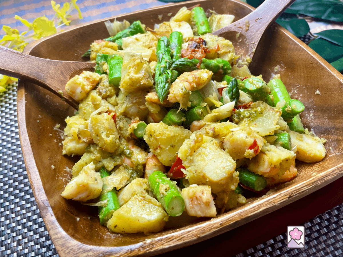Roasted Seafood and Asparagus Salad is loaded with shrimp. Scallops, potatoes, Asparagus, leeks and roasted red pepper all tossed with a pesto.dressing in a wooden salad bowl