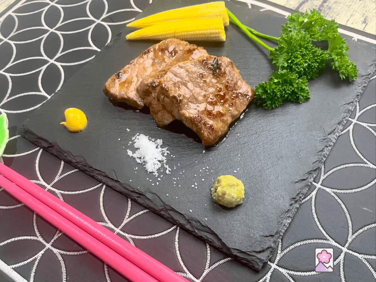 Japanese Roast Beef Strips, prepared sous vide style and then seared, are served on a slate tray with baby corn and parsley