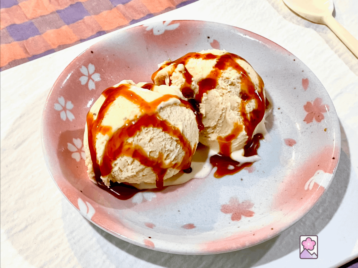 Two scoops of smooth and creamy caramel ice cream on a plate decorated with flowers and bunnies