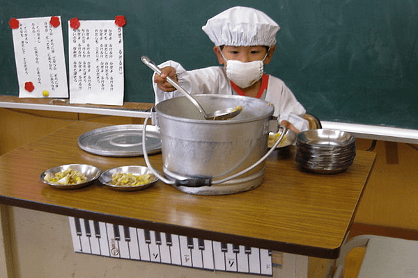 AHLN, CC BY 2.0 <https://creativecommons.org/licenses/by/2.0>, via Wikimedia Commons From a very young age, Japanese kids learn to take care of the school and independently serve school lunch