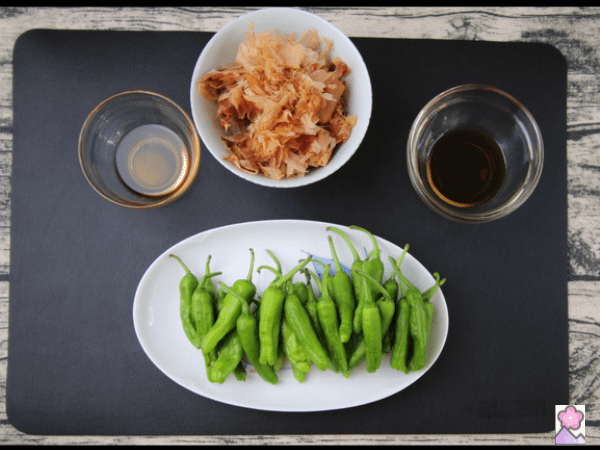 Shishito peppers, Katsuobushi, Soy Sauce and Sesame oils are laid out on this ingredient board