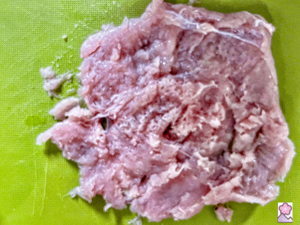Tenderized chicken in a rectangular shape on a cutting board
