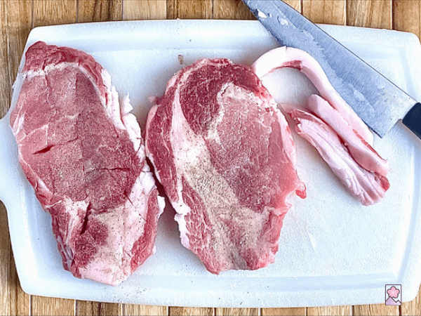 Two Pork chops with fat trimmed off, scored with a knife, and sprinkled with salt and pepper
