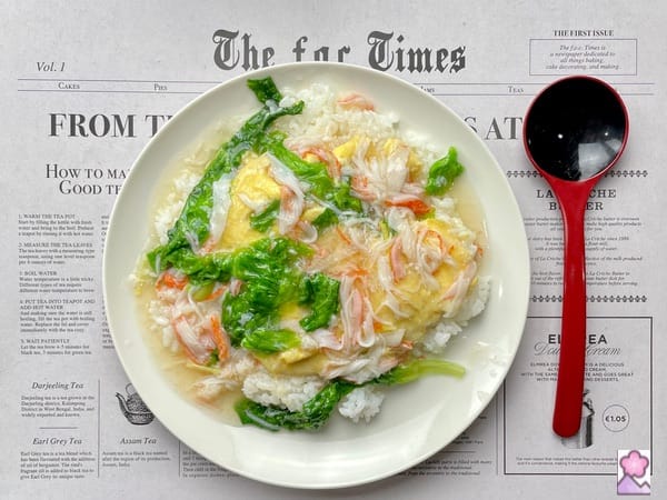 Omelette on white rice with Ankake sauce on a “Newspaper” placemat