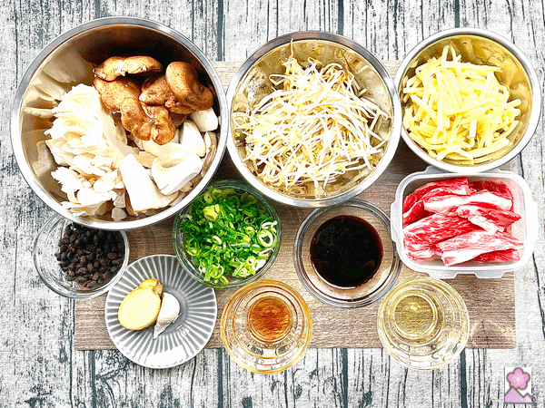 Ingredients laid out on a placemat including beef, bamboo, mung beans and other ingredients and vegetables