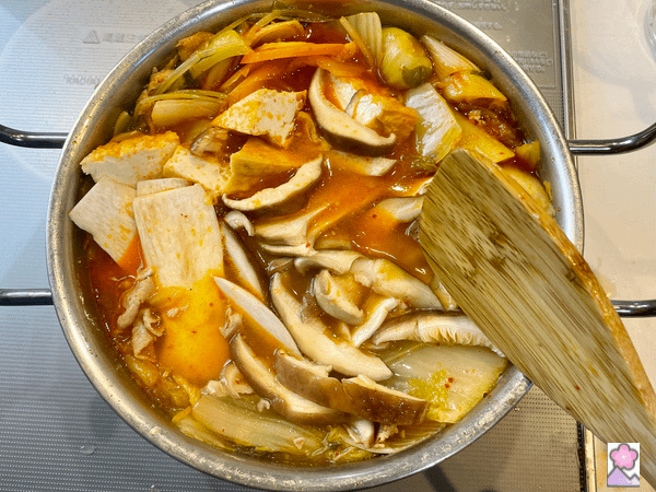 Adding tofu and mushrooms to nabe