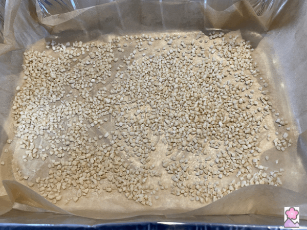 Crushed Almonds on Parchment Paper which is lining a foil pan