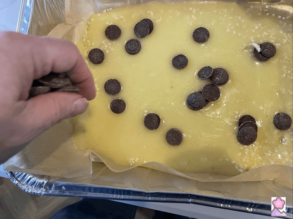 Sprinkling chocolate ships onto the hot offer batter, which is in the foil pan