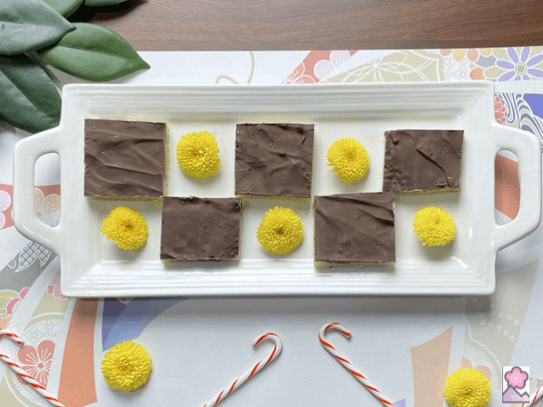 Chocolate Covered Butter Toffee Squares On a white tray in a checkerboard pattern.