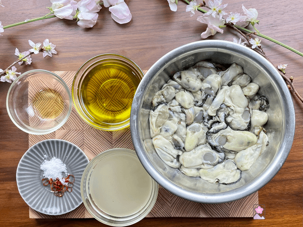 Smokey Marinated Oyster ingredients on a board with pink flowers in the background
