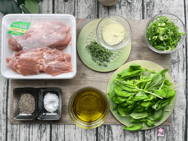 Ingredients for Marinated Basil Chicken on a wooden placemat.