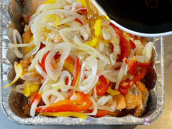 Pouring sauce over the salmon and veggies