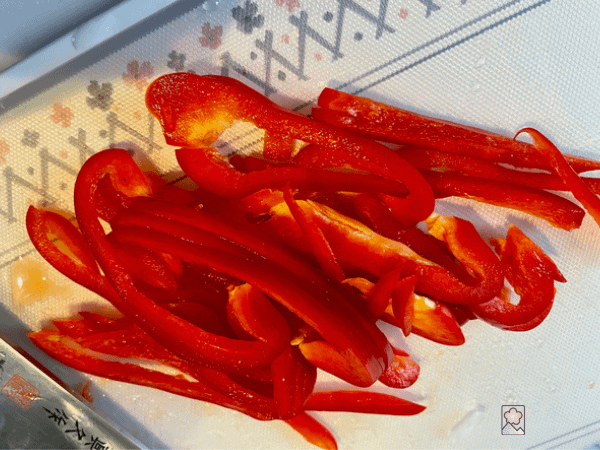 Thinly sliced red pepper on a cutting board