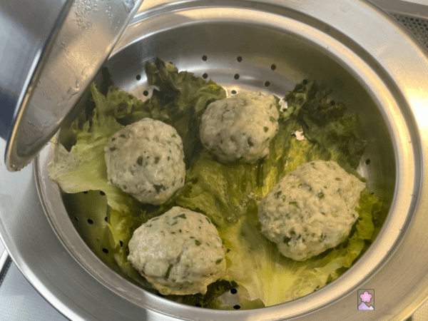 Steamed meatballs in the steamer on a bed of lettuce