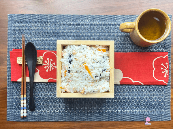 Sushi Rice with Salmon In a wooden box on a red runner