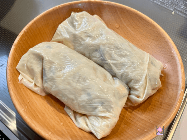 Two yuba rolls in a wooden bowl