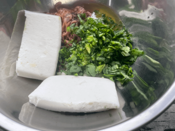 Meatball ingredients in a metal bowl