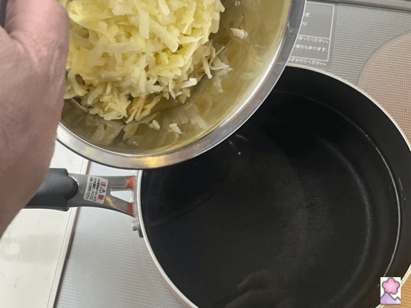 Shredded potato about to be dumped into a pot of boiling water