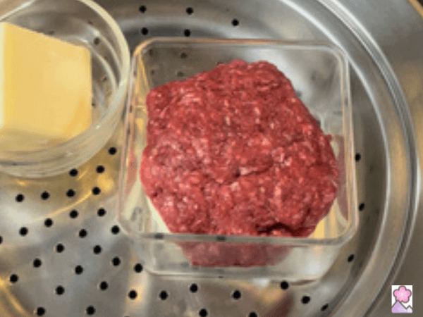 Hamburger and cheese in containers ready to go in the steamer.