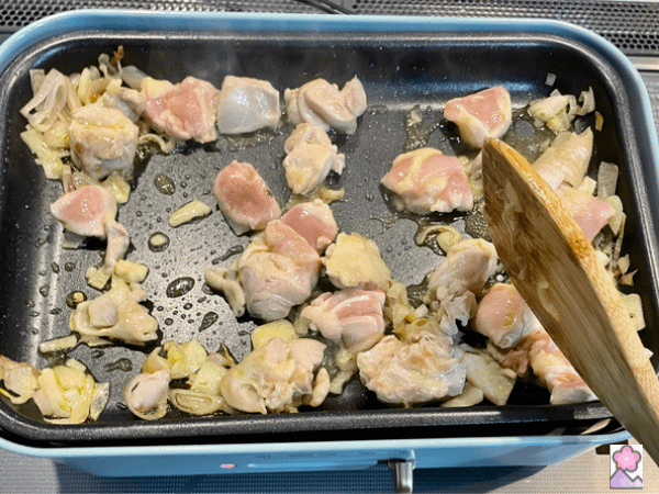 Chicken, shallots and garlic stir fried on a hot plate in oil