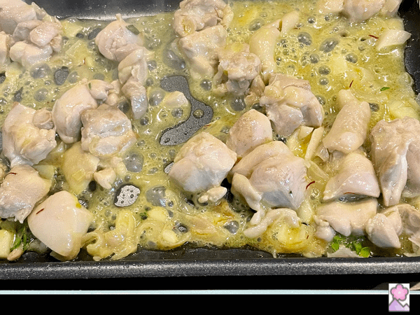 Sautéed chicken in wine and spices on a hot plate