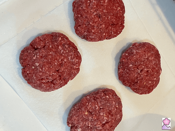 Four beef patties on an absorbent towel