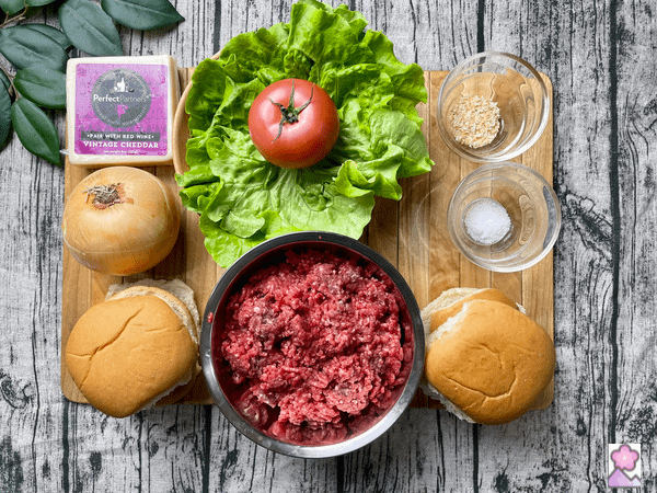 Steamed cheeseburgers ingredients on a wood board