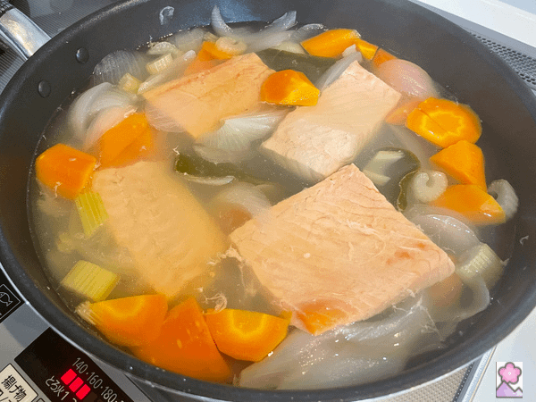 Fish poaching in broth in a large pot