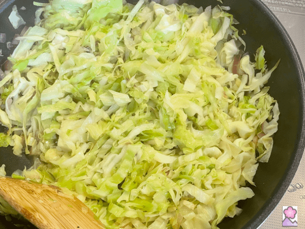 Sautéed cabbage and red onion in a skillet