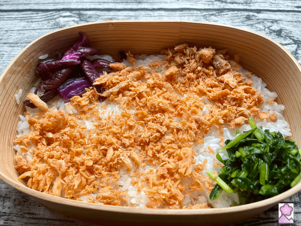 Salmon flakes and tsukemono on a bed of sushi rice