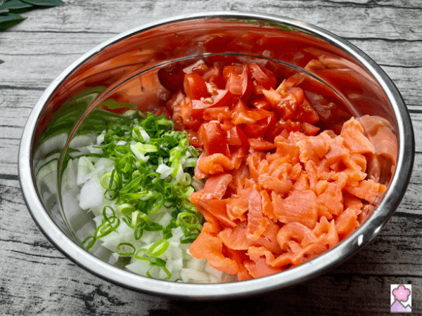 Lomi Lomi Salmon ingredients all diced and placed next to each other in a metallic mixing bowl