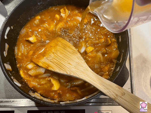 Loco Moco Sauce being stirred in a pot with a wooden spoon