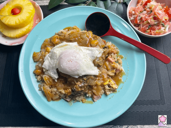Loco Moco on a plate with pineapple and Lomi Lomi Salmon served on the side