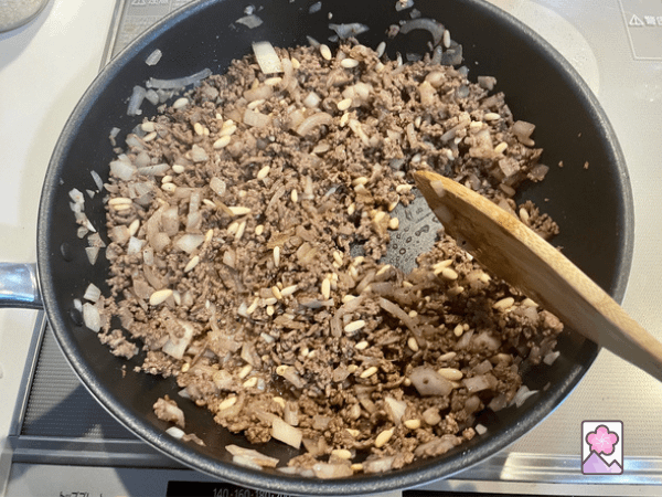 Cooked Kibbeh Filling in a fry pan with a wooden spoon