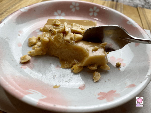 A spoon in a block of peanuttofu, scooping up a creamy piece