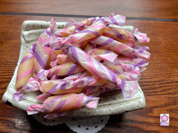 Caramels wrapped in wax paper stacked in a ceramic bowl