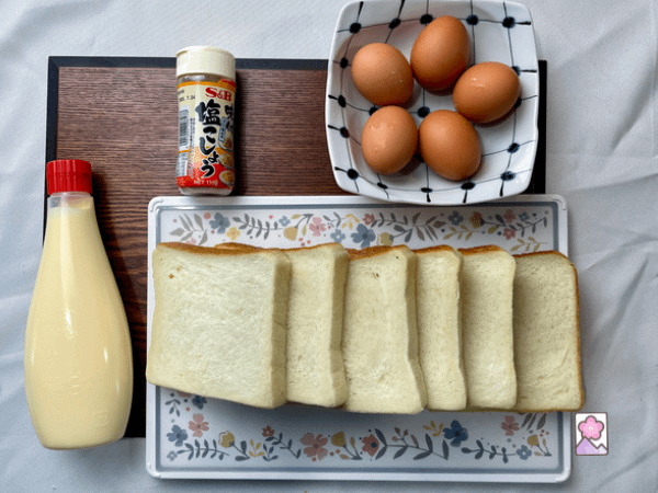 Japanese egg salad ingredients laid out on a board