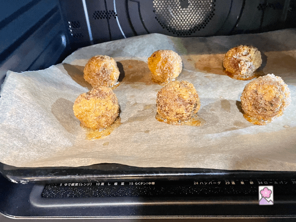 Six Mini Scotch Eggs on a baking sheet in the oven