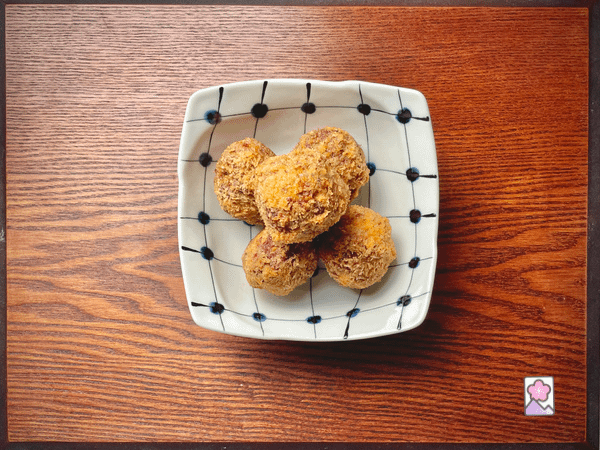 Five cooked mini scotch eggs in a ceramic dish