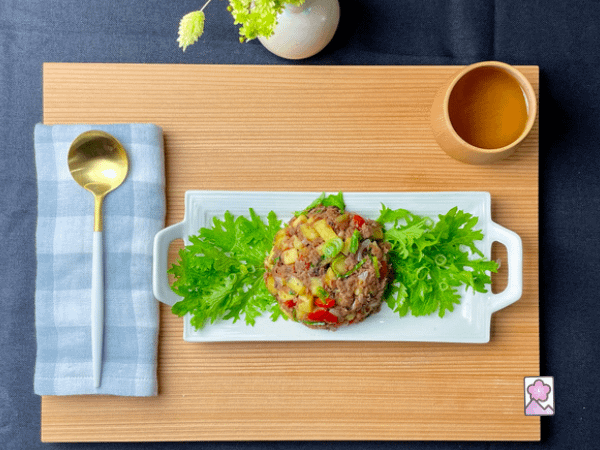 Corned Beef Hash with Japanese Sweet Potatoes served on greens with a golden spoon and a cup of Japanese tea