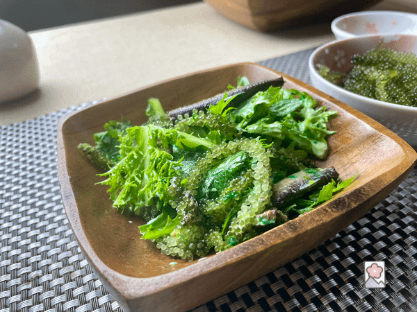 Sea Grass and Smoked Sardine Salad served in a square wooden bowl