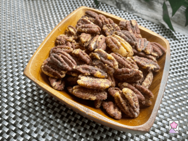 A wood bowl full of Maple Glazed Pecans
